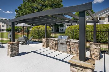 a patio with a barbecue grill and a pergola